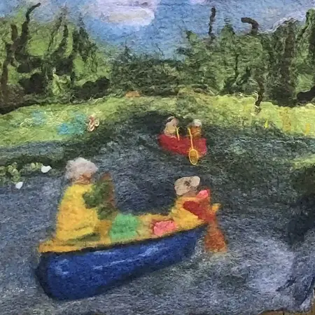 A felted textile of a landscape scene in an impressionist style. The scene features two canoes on the water with a red canoe in the distance, and a blue canoe in the foreground, the figures are wearing yellow life jackets and hats. The landscape is lush with shades of green under a blue sky with white clouds.