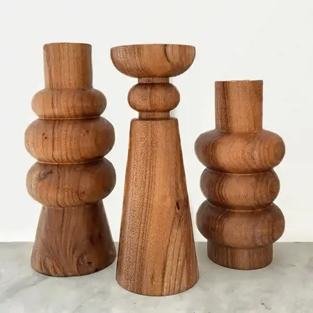 A group of three wood sculptures all with a flat top and bottom and curves.